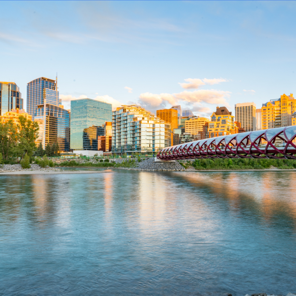 colorful scenic photo of the Peace Bridge in Calgary, Alberta with a background of city buildings.