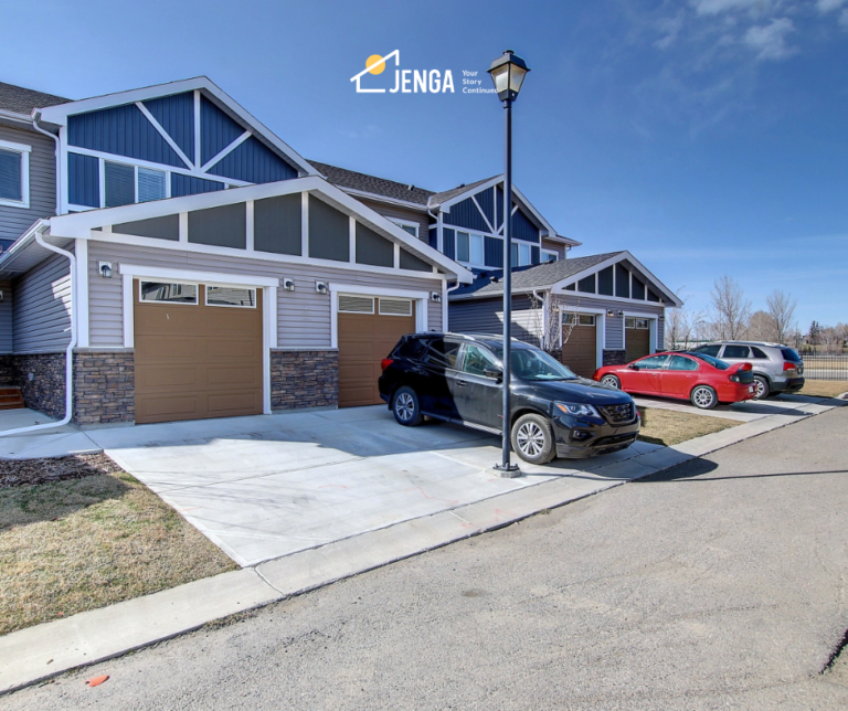 3 bed townhome on a sunny day with a black car outside the garage.