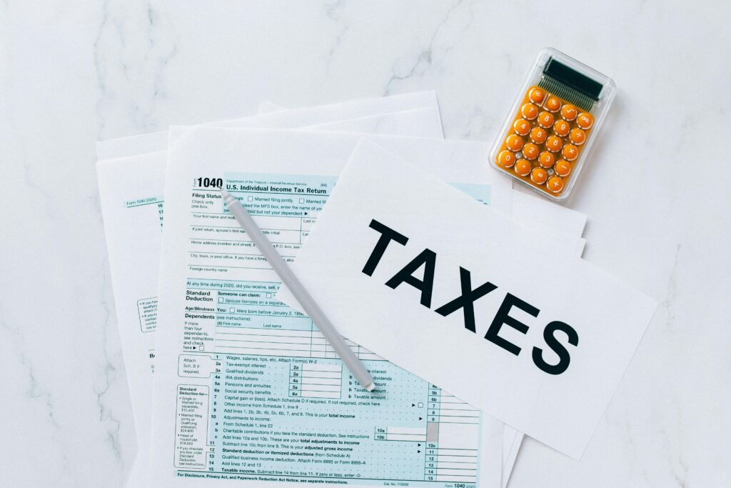 Tax forms on a table with a pen and calculator