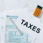 Tax forms on a table with a pen and calculator