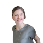 A smiling lady with short hair wearing a silver shirt with a silver necklace.